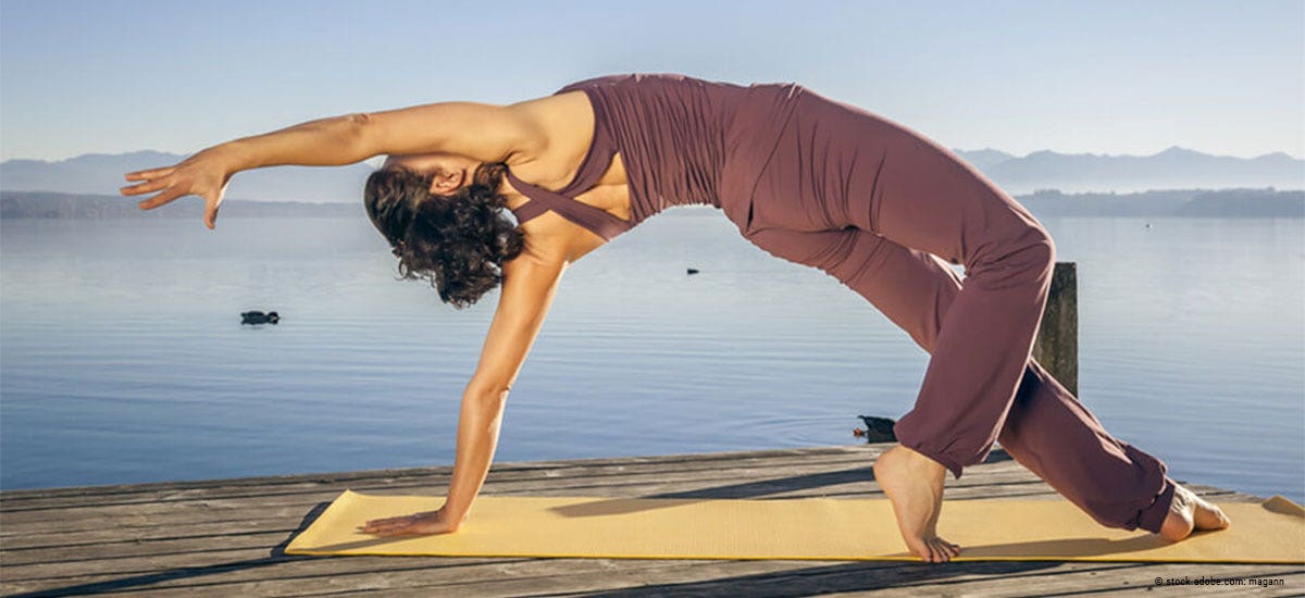 Frau macht Yoga am Wasser